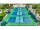 An elevated view of community pickleball courts lined with shady palm trees and well maintained lawns at 2450 Harbourside Dr # 233, Longboat Key, FL 34228