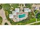 Aerial view showcases a community pool and patio area with landscaping. Adjacent to homes and parking at 2450 Harbourside Dr # 233, Longboat Key, FL 34228