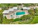 Aerial view of a community pool and patio area surrounded by lush landscaping. Next to outdoor pavilion at 2450 Harbourside Dr # 233, Longboat Key, FL 34228