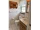 Cozy bathroom featuring a white tiled floor, wooden vanity, and a decorative wooden shelf at 2716 81St E Ave, Ellenton, FL 34222