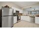 Well-lit kitchen with white cabinetry and stainless steel appliances, seamlessly connected to the living area at 2819 Conch Hollow Dr, Brandon, FL 33511
