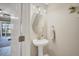 Stylish powder room featuring a pedestal sink, mirror, and decorative accents at 2819 Conch Hollow Dr, Brandon, FL 33511