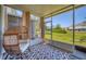 Relaxing screened porch with wicker chair, neutral rug, and an open view of the lush lawn at 2819 Conch Hollow Dr, Brandon, FL 33511