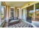 Cozy screened porch with cushioned seating, ceiling fan, patterned rug, and natural light at 2819 Conch Hollow Dr, Brandon, FL 33511