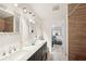 Bathroom featuring double vanity, decorative mirrors, and tiled shower at 2848 Trinidad St, Sarasota, FL 34231