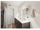 Bathroom with double vanity, decorative mirrors, and a shower with tiled walls at 2848 Trinidad St, Sarasota, FL 34231