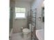 Bright bathroom featuring tile floors, natural light, and a modern metal shelf unit at 306 Island Cir, Sarasota, FL 34242