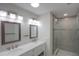 Bathroom featuring marble double vanity, updated lighting, and glass enclosed shower at 306 Island Cir, Sarasota, FL 34242