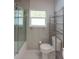 Clean and contemporary bathroom with glass-enclosed tub/shower and open shelving for storage and decor at 306 Island Cir, Sarasota, FL 34242