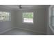 A neutral bedroom features light walls, multiple windows, modern fixtures, and sleek light gray flooring at 306 Island Cir, Sarasota, FL 34242
