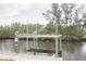 View of a wooden dock and boat lift on a canal at 306 Island Cir, Sarasota, FL 34242