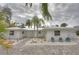 Charming single-story home featuring a white exterior, lovely landscaping and a paved driveway at 306 Island Cir, Sarasota, FL 34242