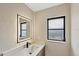 Modern bathroom features a bright LED mirror, white countertop, and black hardware at 3136 Webber St, Sarasota, FL 34239