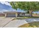 Attractive single-story home showcasing a stone facade, attached garage, and well-maintained lawn, shaded by a large, mature tree at 3136 Webber St, Sarasota, FL 34239