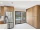 Bright kitchen with pool view, showcasing stainless steel refrigerator and wood cabinets for ample storage at 3136 Webber St, Sarasota, FL 34239