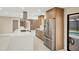 Contemporary kitchen featuring wood-grain cabinets, stainless steel refrigerator, and sleek quartz island with cooktop at 3136 Webber St, Sarasota, FL 34239