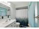 Bathroom features a white vanity with a silver framed mirror and white shower curtain with green forest pattern at 3260 Pinetree St, Port Charlotte, FL 33952