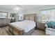 Bedroom features a large bed with a floral patterned comforter, light wood floors, and two side tables at 3260 Pinetree St, Port Charlotte, FL 33952
