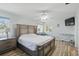 Bedroom boasts a large bed with a floral patterned comforter, light wood floors, and ceiling fan at 3260 Pinetree St, Port Charlotte, FL 33952