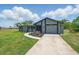 Charming single-story home with a well-maintained lawn, palm trees, and an inviting walkway leading to the front door at 3260 Pinetree St, Port Charlotte, FL 33952