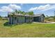 Landscaped home exterior with palms, green lawn, and a view of the neighborhood at 3260 Pinetree St, Port Charlotte, FL 33952