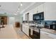 Modern kitchen with stainless steel appliances, white cabinets, and track lighting above at 3260 Pinetree St, Port Charlotte, FL 33952