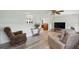 Living room boasts wood floors, a ceiling fan, and two brown cushioned chairs with views to other rooms at 3260 Pinetree St, Port Charlotte, FL 33952