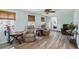 Bright living room with light wood floors, ceiling fan, and two brown cushioned chairs next to side tables at 3260 Pinetree St, Port Charlotte, FL 33952