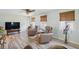 Bright living room offers light wood floors, a ceiling fan, and two brown cushioned chairs with side tables at 3260 Pinetree St, Port Charlotte, FL 33952