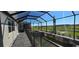 View of the screened lanai with a pool, patio, and a backdrop of green fields at 3531 Night Star Ter, Parrish, FL 34219