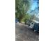 The backyard is visible with trees and blue trash cans, but is filled with debris at 3619 18Th E St, Bradenton, FL 34208