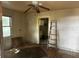 A room with a ceiling fan and ladder, shows damage and disrepair at 3619 18Th E St, Bradenton, FL 34208