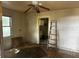 Empty living area with window, ceiling fan, and doorway to a kitchen at 3619 18Th E St, Bradenton, FL 34208