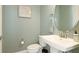 This half-bathroom is painted a relaxing green color with a framed seashell art piece at 3684 Fescue Ln, Sarasota, FL 34232