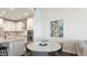 Elegant dining area with a round table, adjacent to a modern kitchen, with views of the living space at 3684 Fescue Ln, Sarasota, FL 34232