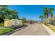 Entrance to the Enclave at Forest Lakes with palm trees and a security gate at 3684 Fescue Ln, Sarasota, FL 34232