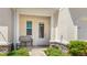 Charming covered front porch with bench seating, decorative stone accents, and lush green landscaping at 3684 Fescue Ln, Sarasota, FL 34232