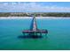 Aerial view of a pier extending into turquoise waters, with people enjoying the beach and pier at 3730 Cadbury Cir # 631, Venice, FL 34293