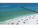 Aerial view of a beautiful beach, showing a long pier, clear water, and scattered beachgoers at 3730 Cadbury Cir # 631, Venice, FL 34293