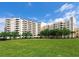 Expansive green lawn and multi-story residential building against a clear blue sky at 3730 Cadbury Cir # 631, Venice, FL 34293