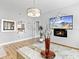 Living room featuring a fireplace, mounted TV, and access to the kitchen at 3730 Cadbury Cir # 631, Venice, FL 34293