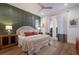 Inviting bedroom with hardwood floors, a decorative green accent wall, and natural light at 408 Magnolia Ave, Anna Maria, FL 34216
