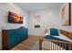Modern bedroom with shiplap walls, wood-style flooring, and a charming blue accent cabinet at 408 Magnolia Ave, Anna Maria, FL 34216