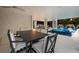 Inviting covered patio with modern dining set, pool and spa in the background at 408 Magnolia Ave, Anna Maria, FL 34216