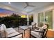 Comfortable, covered outdoor patio with stylish seating offering beautiful sunset views through the lush tropical canopy at 408 Magnolia Ave, Anna Maria, FL 34216