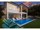 Beautiful outdoor pool area with hot tub, sun loungers, and manicured lawn at dusk at 408 Magnolia Ave, Anna Maria, FL 34216