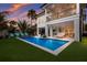 Beautiful backyard with a luxurious pool and seating area at sunset at 408 Magnolia Ave, Anna Maria, FL 34216