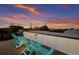 Relax on the rooftop deck with fantastic sunset views overlooking lush tropical foliage from the comfort of blue Adirondack chairs at 408 Magnolia Ave, Anna Maria, FL 34216