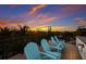 Relax on the rooftop deck with fantastic sunset views overlooking lush tropical foliage from the comfort of blue Adirondack chairs at 408 Magnolia Ave, Anna Maria, FL 34216