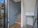 Stylish staircase featuring wood steps, a modern blue accent wall, and natural light at 408 Magnolia Ave, Anna Maria, FL 34216